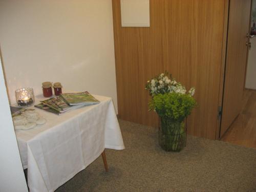a table with a vase of flowers on it at Gästehaus Lässer in Mellau