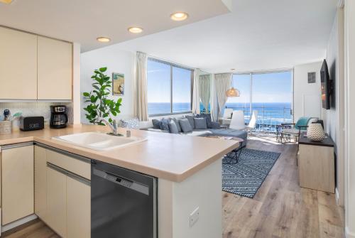 a kitchen and living room with a view of the ocean at Ilikai Collection 12 Corner Oceanfront Condo with amazing views in Honolulu