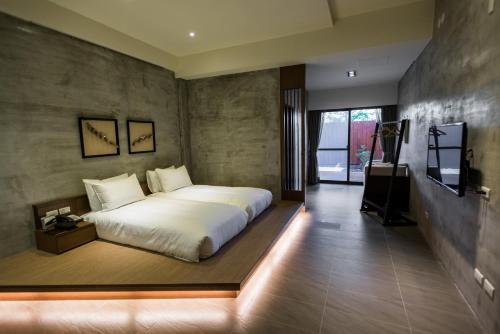 a bedroom with a large white bed and a television at The Silence Manor in Ruisui