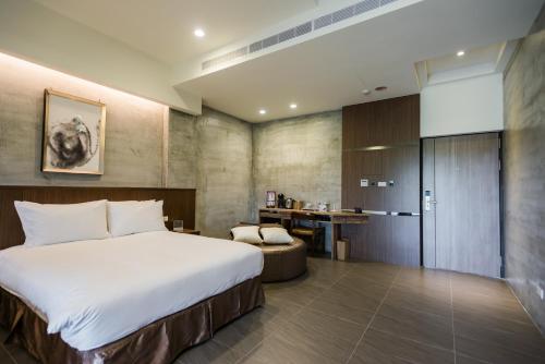 a bedroom with a large bed and a desk at The Silence Manor in Ruisui