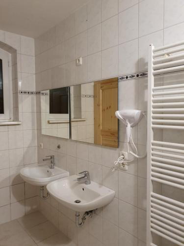 uma casa de banho branca com um lavatório e um espelho em Ferienwohnung "kontaktloser Check-in" em Eisenach