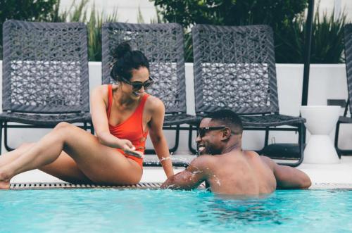 a man and a woman sitting in a swimming pool at Level Downtown LA South Olive in Los Angeles