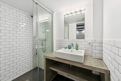 une salle de bain blanche avec un lavabo et une douche dans l'établissement Montmartre Theater Loft, à Paris