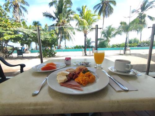 a table with a plate of food and a drink at Hotel Portobelo Convention Center in San Andrés