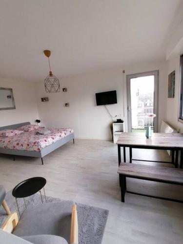un salon avec un lit et une table dans l'établissement Le Tivoli - Balcon Vue jardin, à Dijon