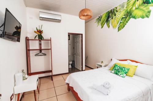 a bedroom with a white bed and a table and chair at Ukinca B&B in Uvita