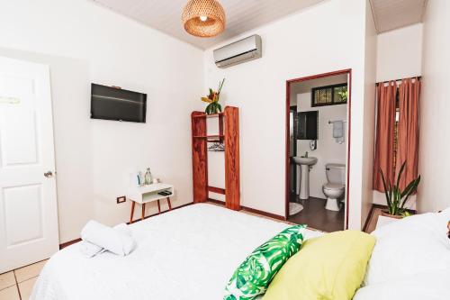 a bedroom with a bed and a bathroom with a toilet at Ukinca in Uvita