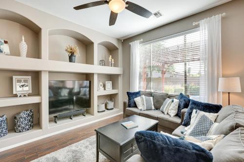 a living room with a couch and a tv at Sunny Arizona Getaway with Heated Pool and Patio! in Surprise