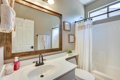 a bathroom with a sink and a toilet and a mirror at Sunny Arizona Getaway with Heated Pool and Patio! in Surprise