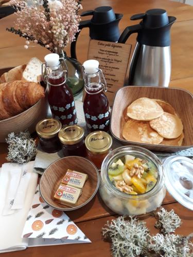 a table topped with plates of food and bread at Les Chalets du Moulin de Valade in Condat-sur-Trincou