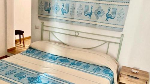łóżko w pokoju z niebiesko-białą ścianą w obiekcie AZIENDA AGRITURISTICA S'ARGALASI - B&B - AFFITTACAMERE Loc S'Argalasi Austis w mieście Austis