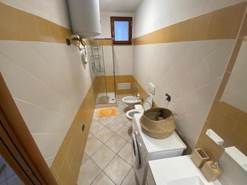 uma casa de banho com 2 lavatórios, um WC e um chuveiro em Residenza Brancadoria em Valledoria