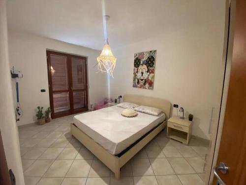 um quarto com uma cama e um lustre em Residenza Brancadoria em Valledoria