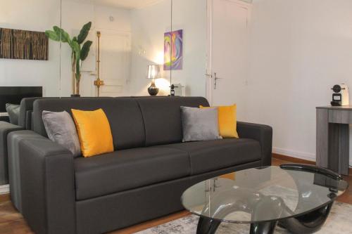 - un salon avec un canapé noir et une table en verre dans l'établissement Pretty love nest close to Père-Lachaise, à Paris