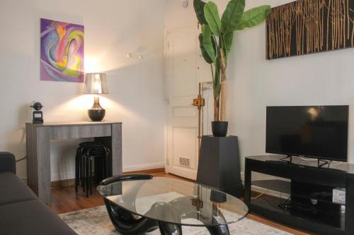 - un salon avec une table basse en verre et une télévision dans l'établissement Pretty love nest close to Père-Lachaise, à Paris