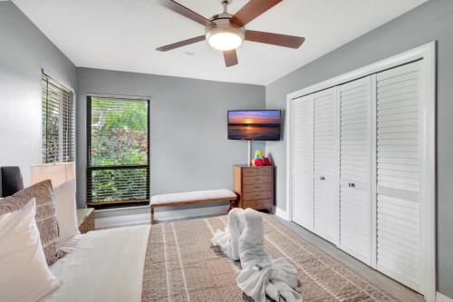 a bedroom with a bed and a ceiling fan at Idyllic Boca Pool Home: 4/2.5 + Study-FAU & Mizner in Boca Raton