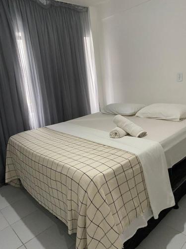 a bedroom with a bed with a checkered blanket at Pousada Mar de Maceió in Maceió