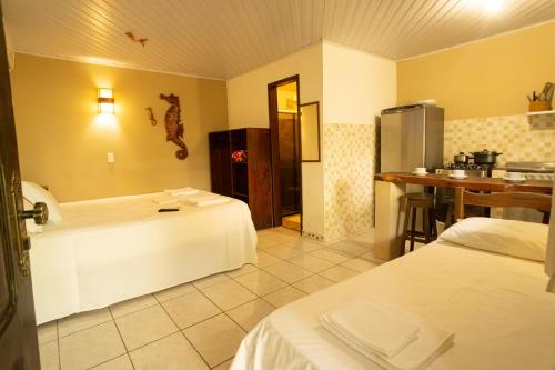 a hotel room with two beds and a kitchen at AquariusApart in Morro de São Paulo