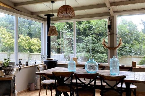 d'une salle à manger avec une table, des chaises et des fenêtres. dans l'établissement La Villa Lumaga, à Étretat