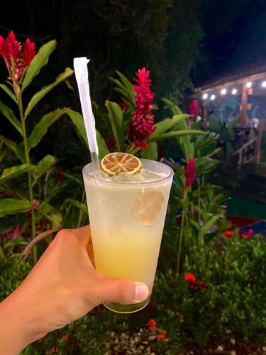 a hand holding a drink with an orange slice in it at Brillasol Airport Hotel in Alajuela City