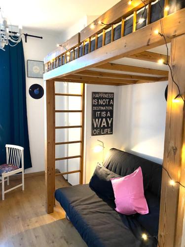 a bunk bed with a couch in a room at Cozy nest in the heart of Helsinki in Helsinki