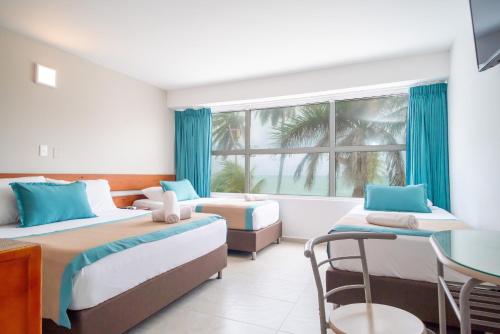 een hotelkamer met 2 bedden en een raam bij Portobelo Beach in San Andrés