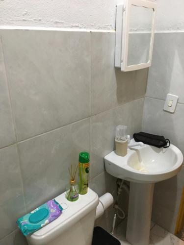 a small bathroom with a toilet and a sink at CARAÍVA House in Caraíva
