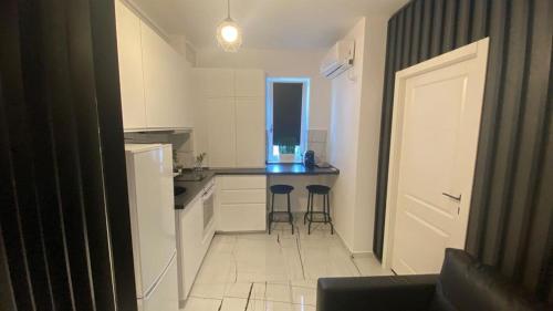 una pequeña cocina con 2 taburetes en una habitación en Q Luxury Apartment - Palas Center, en Iaşi