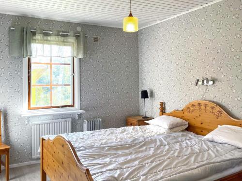 um quarto com uma cama e uma janela em Holiday home BENGTSFORS VI em Bengtsfors