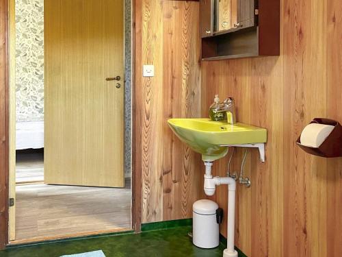 a bathroom with a yellow sink and a door at Holiday home BENGTSFORS VI in Bengtsfors