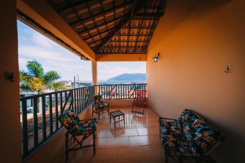 Un balcón con sillas y vistas al océano. en POUSADA ELMIRA´S BELA VISTA, en Ouro Branco