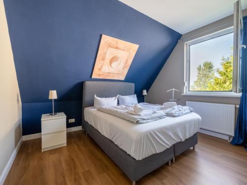 BastorfにあるCozy Apartment in Bastorf with Gardenの青い壁のベッド付きの青いベッドルーム1室
