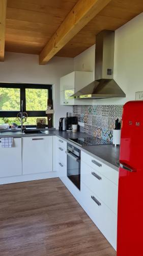 a kitchen with white cabinets and a red refrigerator at Nillhof in Fischerbach