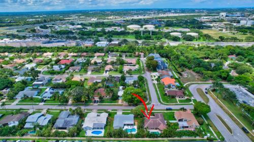 an aerial view of a suburb with a red arrow pointing to a house at Idyllic Boca Pool Home: 4/2.5 + Study-FAU & Mizner in Boca Raton