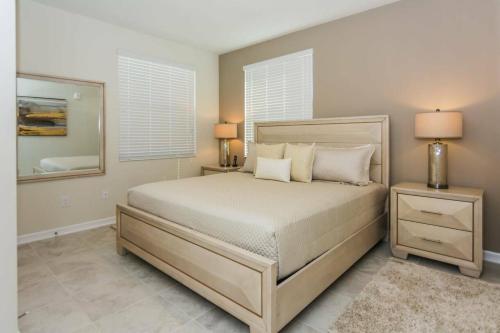 sypialnia z łóżkiem z 2 stolikami nocnymi i lustrem w obiekcie Awesome Apartment at Storey Lake SL47318 w mieście Kissimmee