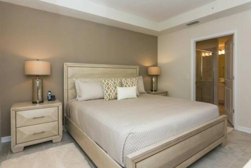 - une chambre avec un lit, 2 tables de nuit et 2 lampes dans l'établissement Stunning Apartment at Storey Lake SL47317, à Kissimmee