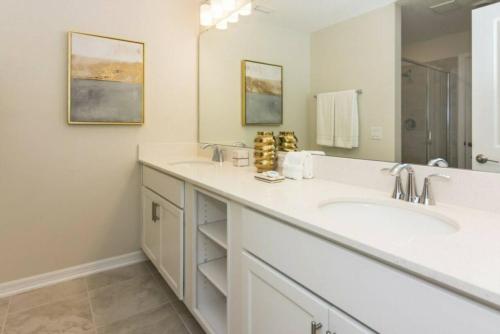 ein Badezimmer mit zwei Waschbecken und einem großen Spiegel in der Unterkunft Stunning Apartment at Storey Lake SL47317 in Kissimmee