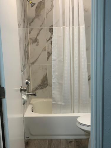 uma casa de banho com uma banheira, um WC e um chuveiro em HomeStay Lodge em Pensacola