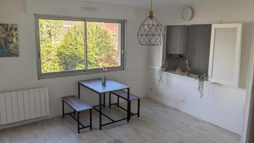 a kitchen with a table and two chairs and a window at Le Tivoli - Balcon Vue jardin in Dijon