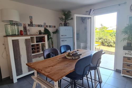 une cuisine avec une table en bois et des chaises bleues dans l'établissement LA VILLA DE AUDREY MER ET MONTAGNE, à Santa-Lucia-di-Moriani