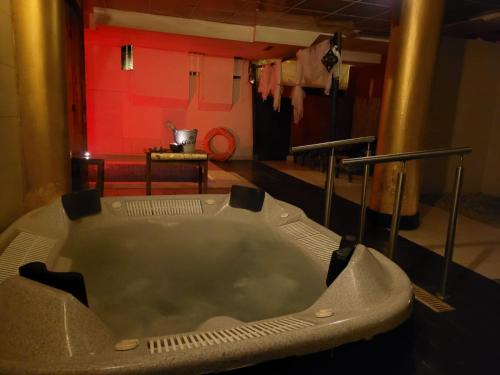 bañera en una habitación con pared roja en Agua Viva Eco H Wellness Castro Urdiales en Castro-Urdiales