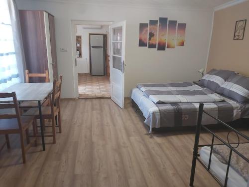 a bedroom with a bed and a table and a dining room at Sweet Home Apartman Szilvásvárad in Szilvásvárad