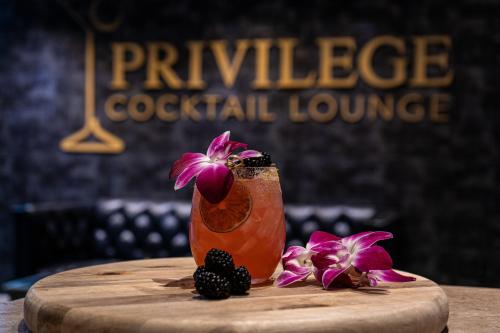 a drink sitting on top of a table with flowers at Albion Hotel in Miami Beach