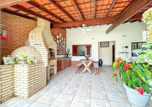 un patio al aire libre con una mesa y una pared de ladrillo en Casa com churrasqueira e piscina em Itanhaem, en Itanhaém