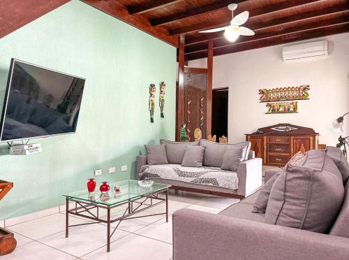 una sala de estar con un sofá y una mesa en Casa com churrasqueira e piscina em Itanhaem, en Itanhaém