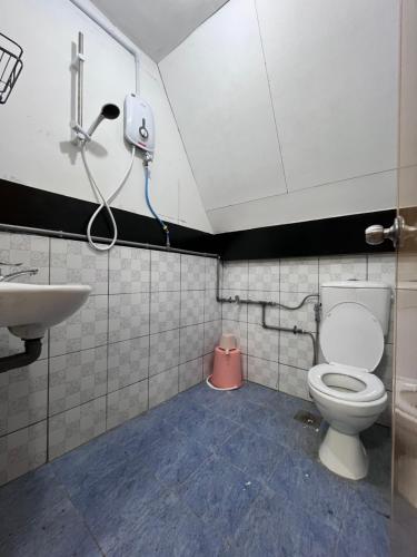 een badkamer met een toilet en een wastafel bij Saiheng Cabin Homestay in Kota Belud