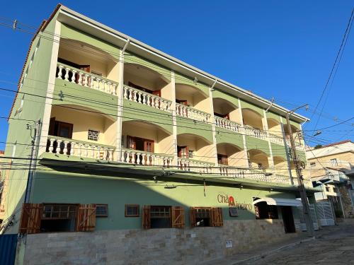 a building with a balcony on the side of it at Hotel Chão Mineiro in São Thomé das Letras