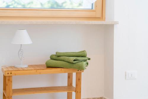 uma pilha de toalhas verdes sentadas numa mesa ao lado de uma janela em Casa Coletta em Bosco Chiesanuova