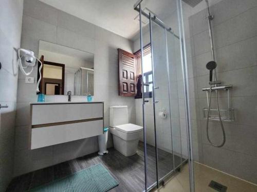 uma casa de banho com um WC e uma cabina de duche em vidro. em Villa Salada on the Ocean Shore em Caleta de Fuste