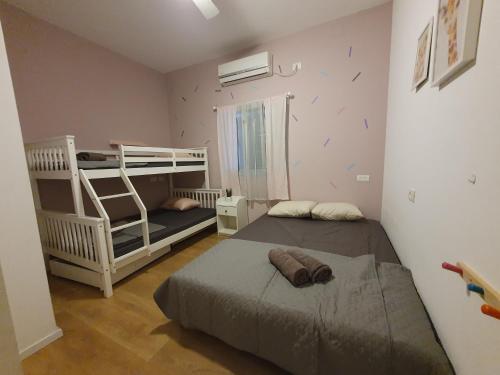 a bedroom with two beds and a bunk bed at וילה אל מול גלעד in Reẖov